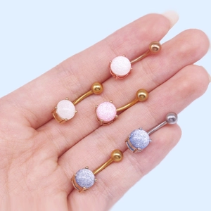 Détails de cinq piercings de nombril avec pierres colorées en finitions or et argent