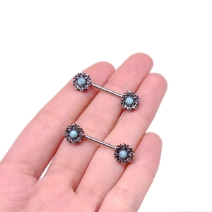 Detailed view of silver nipple ring with blue stone in a sunflower shape design