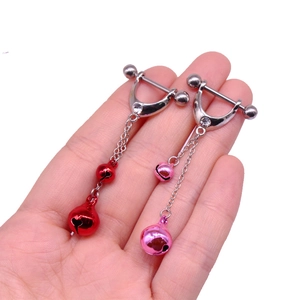 Detail view of steel nipple rings with colorful bells and sparkling crystal accents