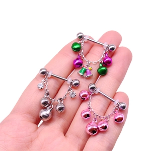 Detailed close-up of nipple rings with colorful bells and sparkling crystal rhinestones