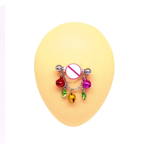 Detail of silver nipple bar with colorful bells and green rhinestones on a silicone model