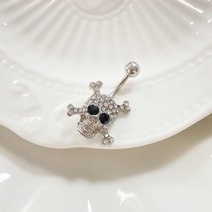 Detailed view of punk skull belly button ring with sparkling crystals and black stone eyes