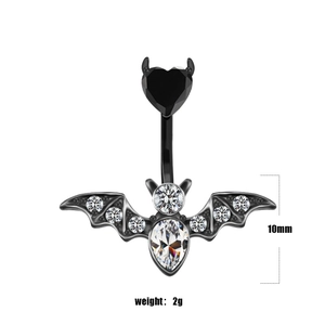 Macro detail of bat belly ring with black heart gem and pear-shaped zircon pendant