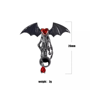 Gothic bat navel ring with red heart zircon and skeleton hand detail macro view