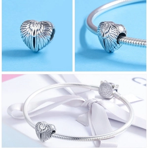 Detailed views of a heart-shaped angel wing charm with a white gift box and silver chain