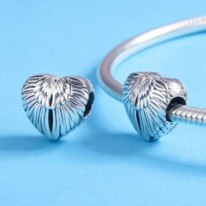 Detailed silver heart charm with feather texture on a snake chain bracelet for women