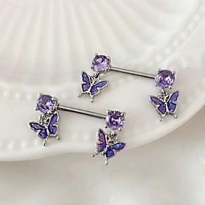 Dettaglio di piercing al capezzolo argento con zirconi viola e pendenti a farfalla scintillanti