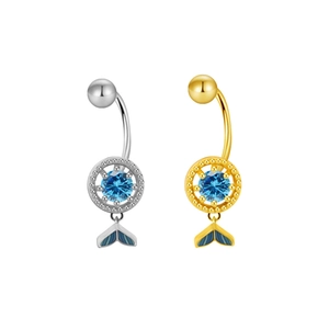 Detail view of silver and gold belly rings featuring blue stones and whale tail charms