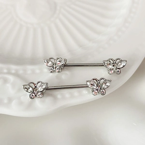 Detailopname van vlinder tepelpiercings met heldere zirkonia op een wit bordje
