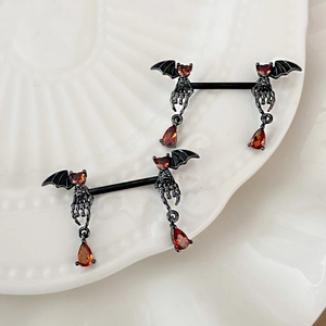 Makro-Detail von Gothic Brustwarzenringen mit schwarzen Fledermausflügeln und Steinen