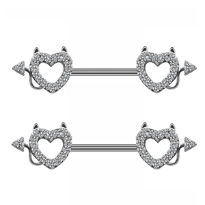 Detail van zilveren duivel hart tepelpiercings met fonkelende zirkonia versiering