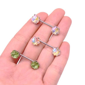 Detailansicht von Schmetterlings- und Kleeblatt-Piercings in bunten und grünen Farben