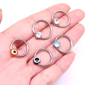 Close-up of five captive bead rings with evil eye and cubic zirconia charms