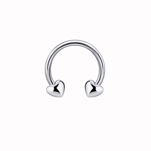 Detail shot of a silver horseshoe nose ring featuring polished heart-shaped ends