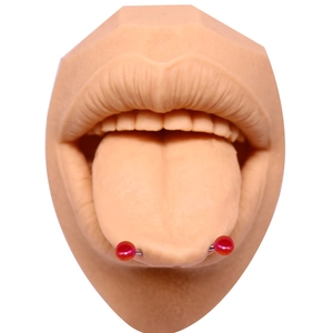 Détail d'un piercing de langue en métal avec deux perles rouges nacrées sur un modèle en silicone
