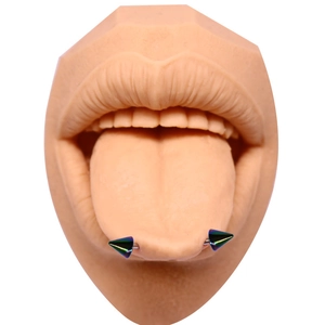 Vue macro d'un piercing de langue coloré avec pointes sur un modèle en silicone