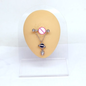 Detail of silver nipple ring with purple planet and alien head pendant on body model
