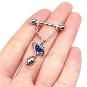 Detail of silver nipple ring with blue glitter planet and alien face charm pendants