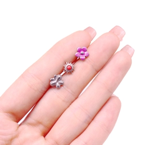 Vue détaillée de mini piercings de langue avec fleur en émail violet et papillon argenté