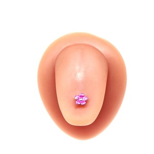 Détail macro d'un piercing de langue fleur mauve avec texture radiale sur support