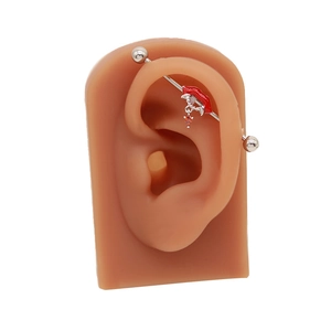 Detail eines Industrial-Barbells mit roten Lippen und birnenförmigem Zirkon-Anhänger