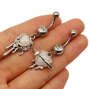 Detail of liquid metal navel rings with opal heart and arrow charms on medical steel