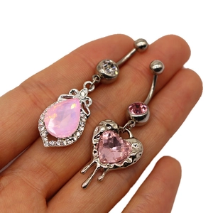 Detailed view of silver belly rings featuring pink pear and heart-shaped gemstones