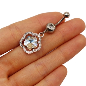 Macro shot of silver belly ring featuring a sparkling hollow flower pendant with crystals