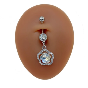 Detailed macro view of silver belly ring with a five-petal flower and sparkling crystals