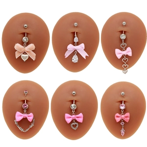 Bauchnabelpiercing-Set mit rosa Schleifen und Herz-Anhängern auf silbernen Metallsteckern