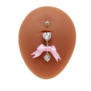 Detailansicht des silbernen Bauchnabelpiercings mit Herz-Zirkonia und rosa Schleife am Model