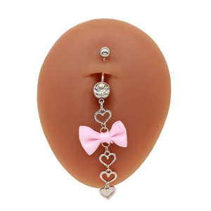 Detail eines Herz-Bauchnabelpiercings mit rosa Schleife und Zirkonia auf Silikonmodell