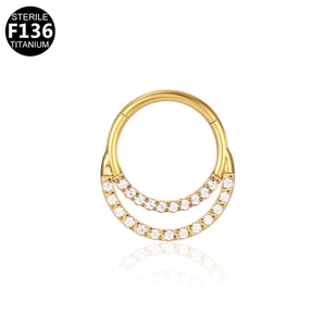 Macro detail of sterile F136 titanium gold hinged ring with double row of clear crystals