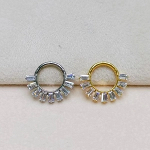 Detailed macro view of silver and gold titanium nose rings with baguette-cut zircons