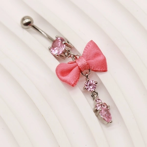 Detaillierte Makroansicht von pinkfarbenem Bauchnabelpiercing mit Schleife und Anhänger