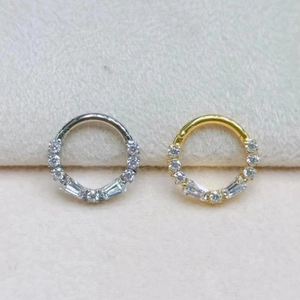 Detail view of gold and silver F136 titanium clicker rings with marquise cut cubic zirconia