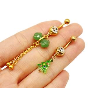 Detail of gold navel rings with green bow tassel and colorful Christmas tree charms
