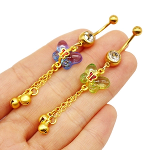 Detailed view of golden butterfly navel rings with gradient wings and small bell dangles