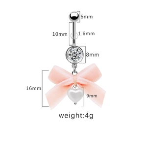 Makro-Detail des Bauchnabelpiercings mit rosa Schleife, Herzanhänger und Zirkonias