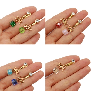 Dettaglio di finti piercing all'ombelico con fiocco in acrilico in vari colori
