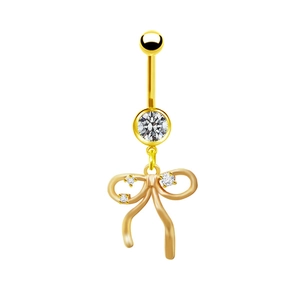 Dettaglio di un piercing all'ombelico dorato con fiocco e pendente in zirconia bianca
