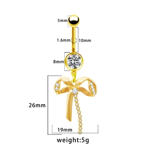 Dettaglio di un piercing all'ombelico dorato con fiocco, zirconi e dimensioni