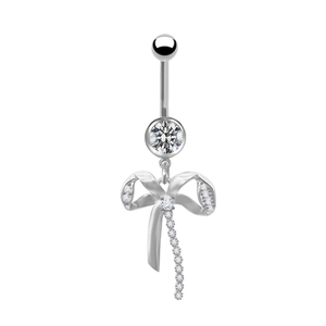 Dettaglio di un piercing all'ombelico in argento con fiocco e cristalli luccicanti