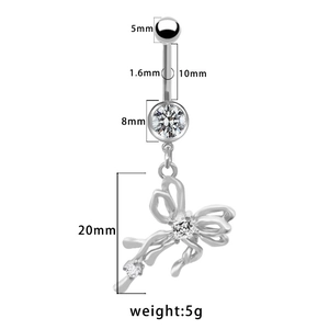 Dettaglio macro del piercing all'ombelico in argento con fiocco e zirconi lucidi