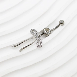 Dettaglio del piercing all'ombelico in argento con fiocco e zirconi brillanti
