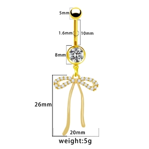 Dettaglio del piercing all'ombelico dorato con ciondolo a fiocco e cristalli brillanti
