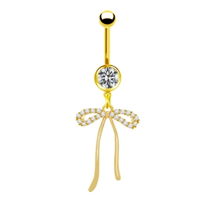 Dettaglio di un piercing all'ombelico dorato con fiocco e pietre di zircone lucide