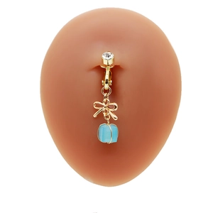 Dettaglio macro della clip per ombelico a fiocco senza piercing con gemma blu e oro
