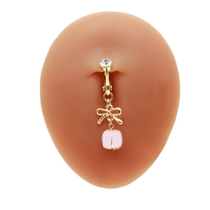 Dettaglio della clip per ombelico con fiocco e perla rosa su modello in silicone