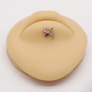 Macro detail of butterfly labret stud with pink and purple pear-shaped zircons